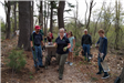 A volunteer crew walks along the trail with spades and shovels