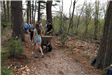A volunteer pushes a cart on the trail as others go on ahead.